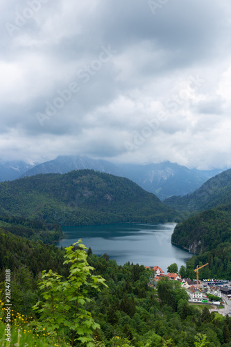 Panaramic skyline of Alpsee  Alps mountains  Bavaria  Germany. Spring summer time. Postcard view. Blue sky and green fields. Postcard view.