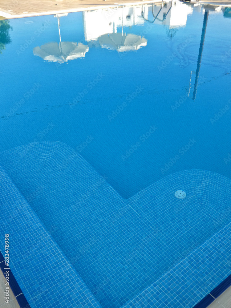 Swimming pool reflection of parasols and steps, Naxos, Greek Islands