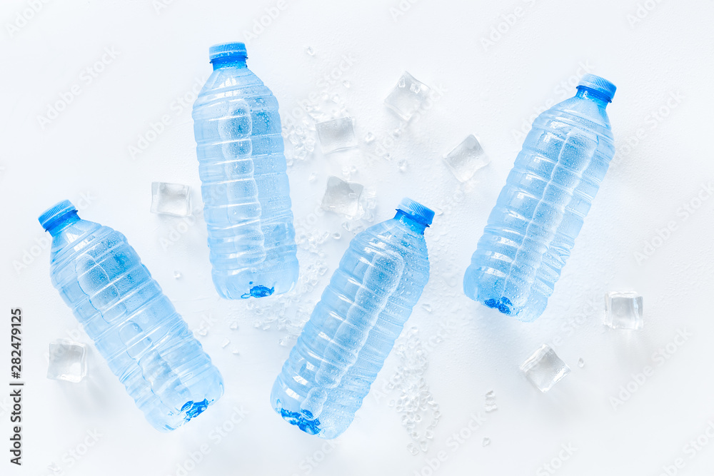 Pure frozen water in plastic bottles on white background top view