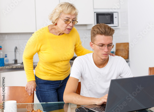 Guy and mom working with laptop