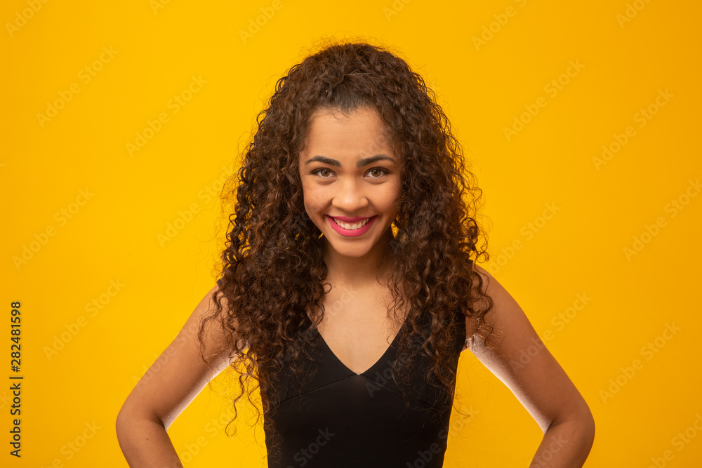 Beautiful young woman with curly hair on yellow background Beautiful young woman with curly hair on yellow background