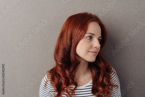 Fototapeta Thoughtful young woman with long red hair