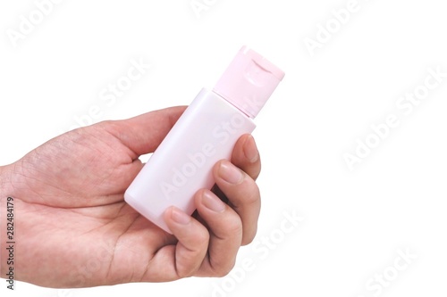 Human hand and pink plastic bottle isolate on white background