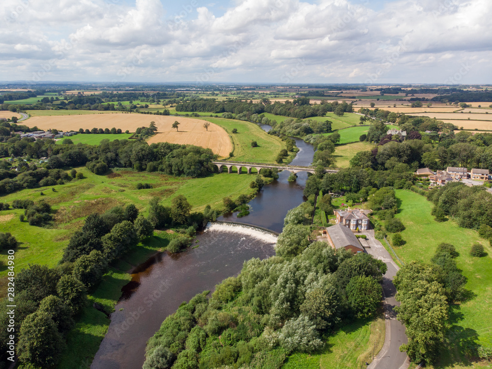 Aerial photo of the the historic Tadcaster Viaduct and River Wharfe located in the West Yorkshire British town of Tadcaster, taken on a bright sunny day