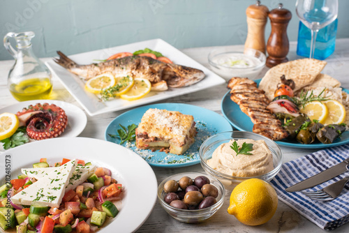 assorted popular greek plates on rustic wooden background