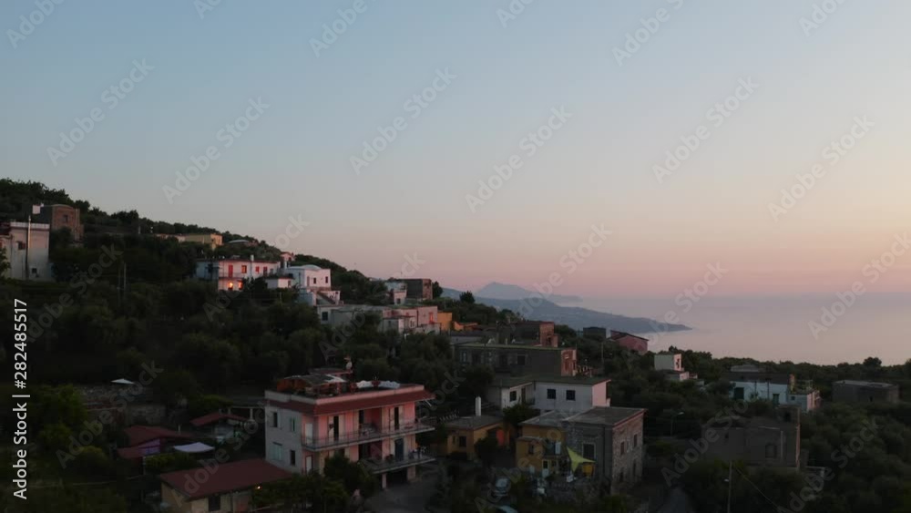 Flying up and over the Vico Equense hillside to reveal sunset over the Naples Gulf in Italy