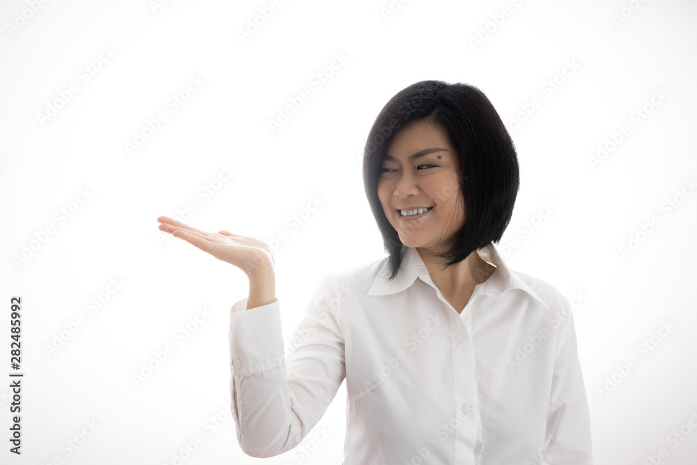 Asian middle-age female model, shoulder hair Raise her hands about shoulders Make hands like invitations Lift products concept. Smiling faces.Copy space on the open hand palm for text White background Asian middle-age female model, shoulder hair Raise her hands about shoulders Make hands like invitations Lift products concept. Smiling faces.Copy space on the open hand palm for text White background
