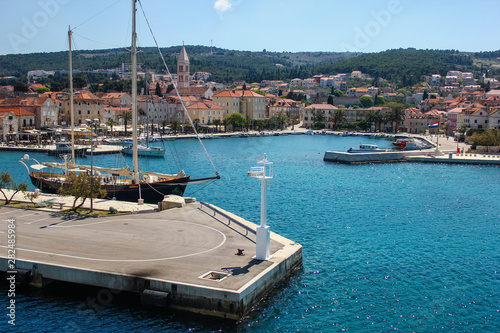 Supetar on Brac Island, Croatia. Arriving by Ferry from Split. Panoramic view on the harbor from the side of the sea on a clear blue sky day. photo