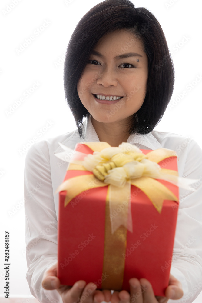 Happy Asian middle-aged female model Holding a red gift box Submit to you. Present for Christmas Birthday New year or Valentine’s day. White background Happy Asian middle-aged female model Holding a red gift box Submit to you. Present for Christmas Birthday New year or Valentine’s day. White background