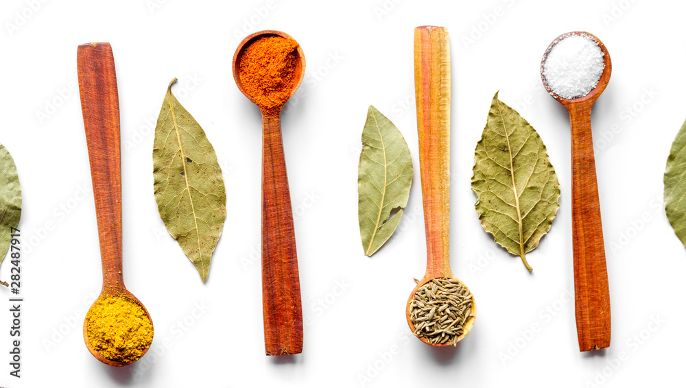 spices in wooden spoons on white background top view spices in wooden spoons on white background top view