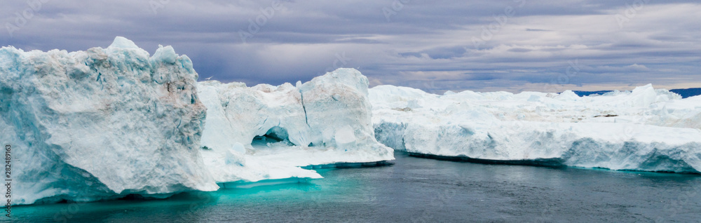 Greenland Iceberg landscape of Ilulissat icefjord with giant icebergs. Icebergs from melting glacier. Arctic nature.