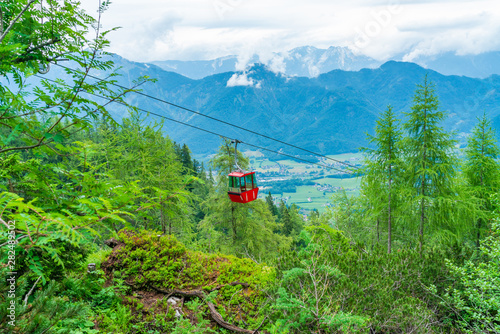 Colorful vintage gondola of Mount Katrin cable car and panoramic alpine view of peaks over Bad Ischl, Salzkammergut, Austria