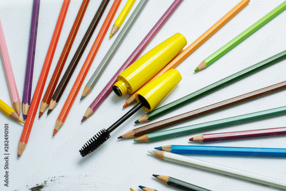 yellow mascara among pencils on a white background yellow mascara among pencils on a white background
