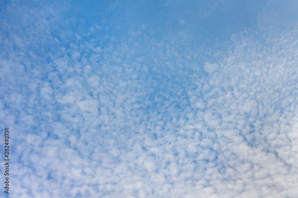 Blue sky with small white clouds, background for design_
