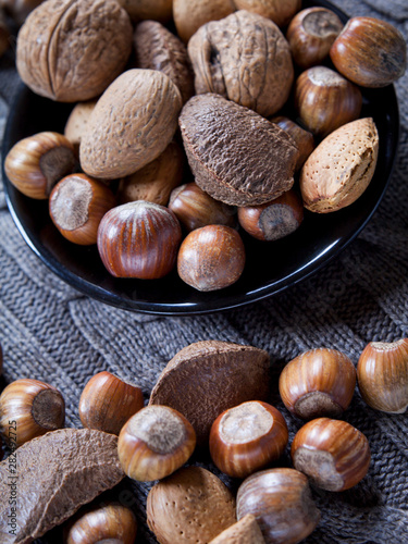 Mixed nuts in shells on the natural background: hazelnut, walnut, Brazil nut and almond.