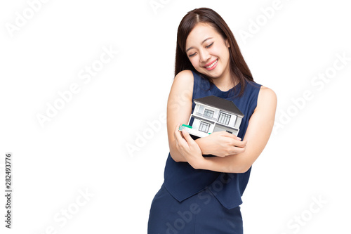 Young Asian woman smiling and hugging dream house sample model isolated over white background, Real estate and home insurance concept