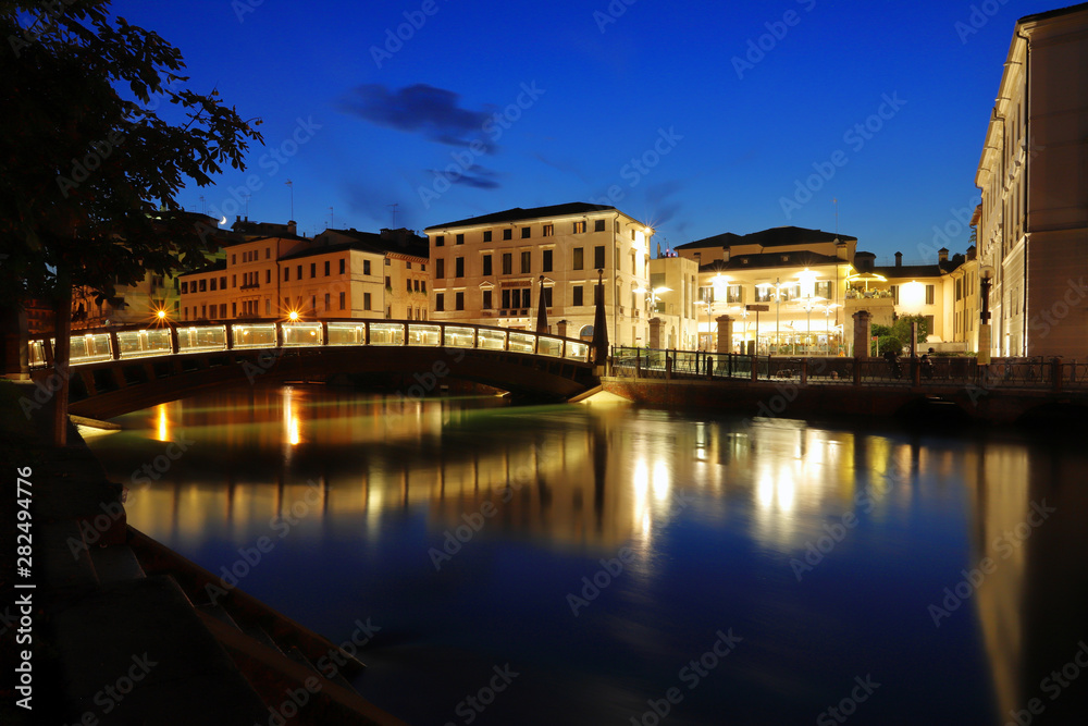 historical buildings and bridge on the river in treviso city in italy