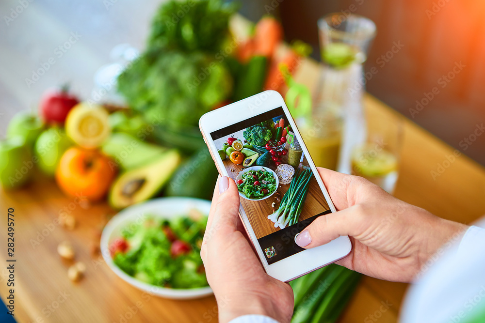 Woman hands take smartphone food photo of vegetables salad with tomatoes and fruits. Phone photography for social media or blogging. Vegan lunch, vegetarian dinner, healthy diet Woman hands take smartphone food photo of vegetables salad with tomatoes and fruits. Phone photography for social media or blogging. Vegan lunch, vegetarian dinner, healthy diet