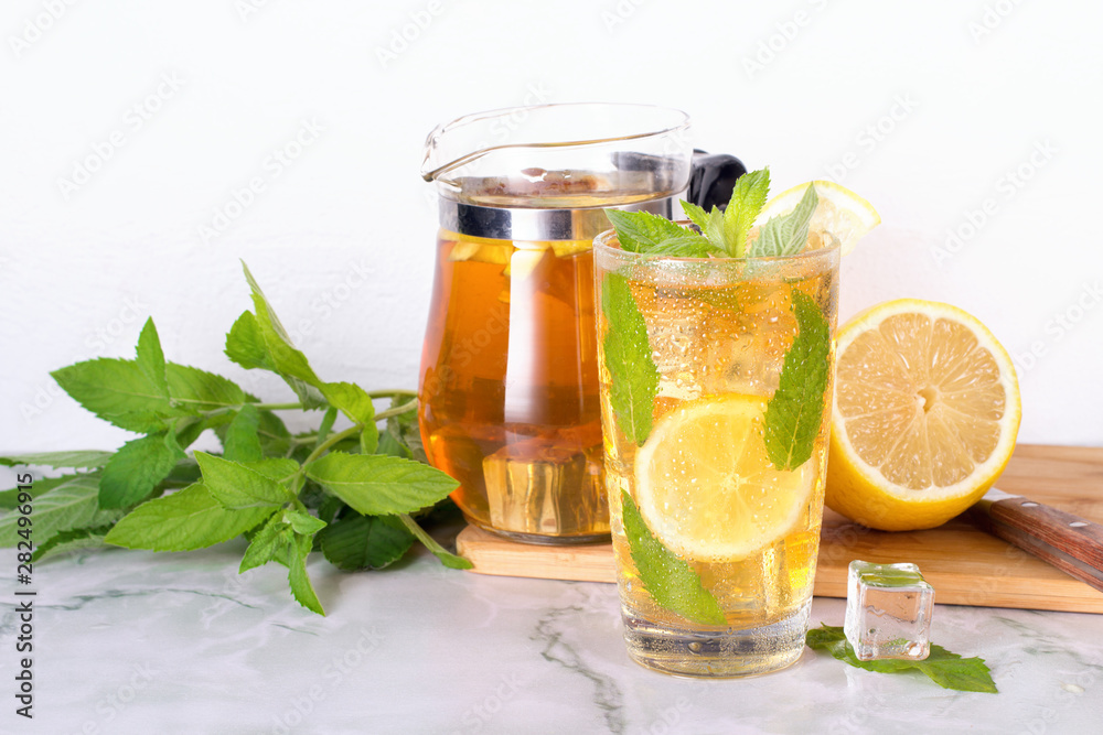 Glass of iced tea with mint and lemon on marble table. Cold drink. Glass of iced tea with mint and lemon on marble table. Cold drink.