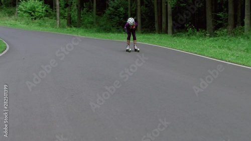 Wallpaper Mural TRACKING Caucasian female professional biathlete roller skiing downhill on a forest track during mid-season practice in summer. ARRI Alexa Mini with Cooke S4 prime lenses RAW graded footage Torontodigital.ca