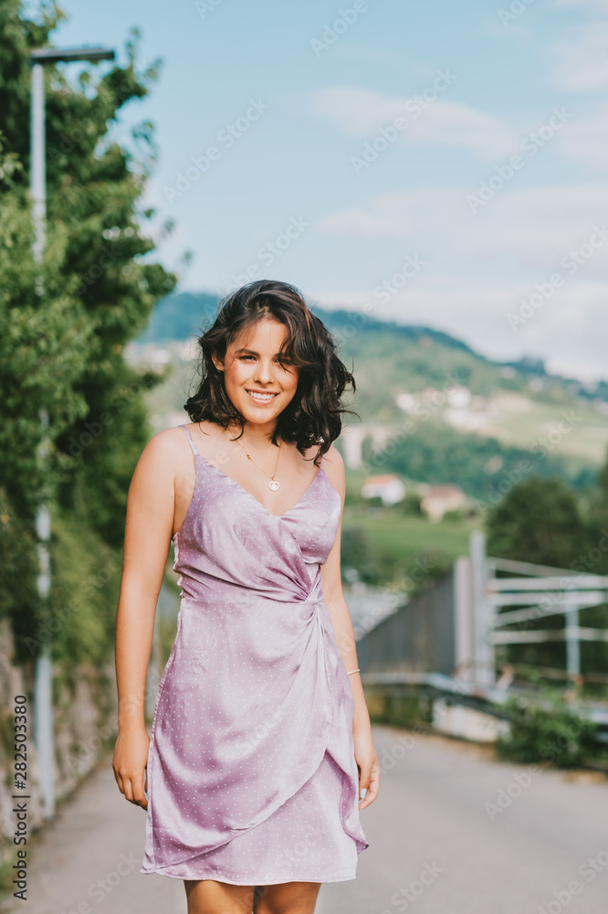 Happy young woman dancing on the street, wearing purple dress, happiness and freedom Happy young woman dancing on the street, wearing purple dress, happiness and freedom