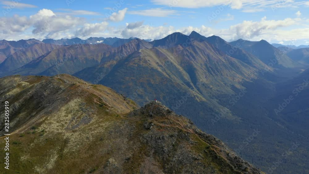 Aerial Forward: Man Standing On Top Of Rocky Mountain, Overlooking Valley And Mountains - Chugach National Forest, Alaska Aerial Forward: Man Standing On Top Of Rocky Mountain, Overlooking Valley And Mountains - Chugach National Forest, Alaska