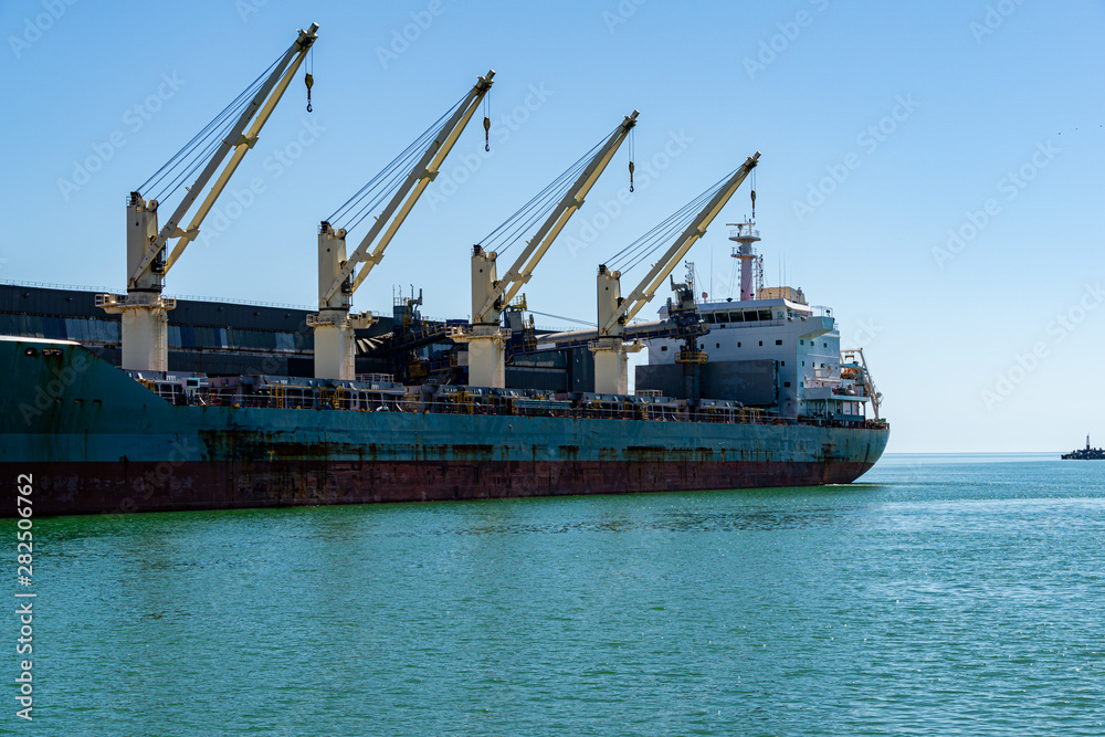 Large blue sea ship dry cargo ship or bulk carrier  in the emerald waters of the Black Sea. Sunny day