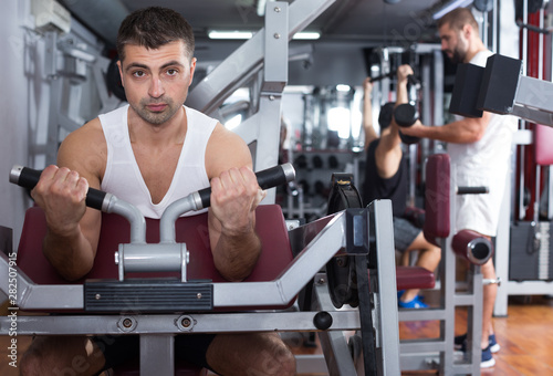Man training on fitness machine in gym