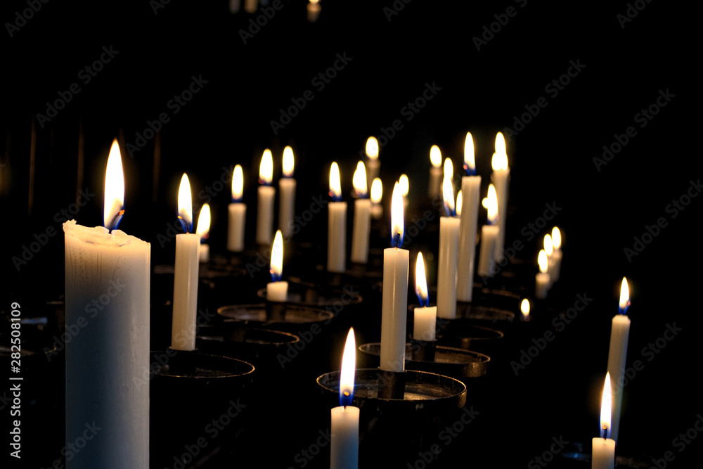 White candels in a church in the darkness. White candels in a church in the darkness.