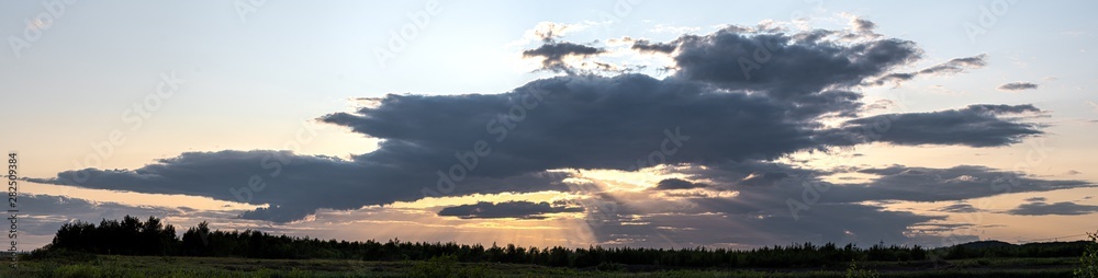 Panorama Sunset - Sun Hiding Behind Dark Clouds Creating God Rays