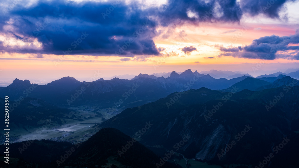 Sunlight bursts through the clouds in the austrian alps in tannheimer tal near vilsalpsee, reutte, tyrol. Valley, From top of the mountain gaishorn. Purple twilight Sunlight bursts through the clouds in the austrian alps in tannheimer tal near vilsalpsee, reutte, tyrol. Valley, From top of the mountain gaishorn. Purple twilight