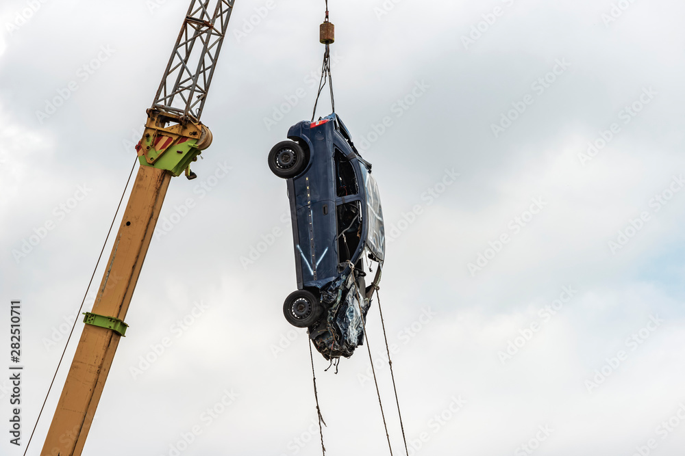 wrecked emergency shapeless car lift on ropes on a crane. wrecked emergency shapeless car lift on ropes on a crane.