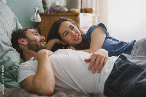 Couple relaxing and talking on bed