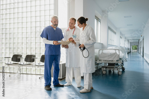 Doctors discussing medical record in hospital corridor photo