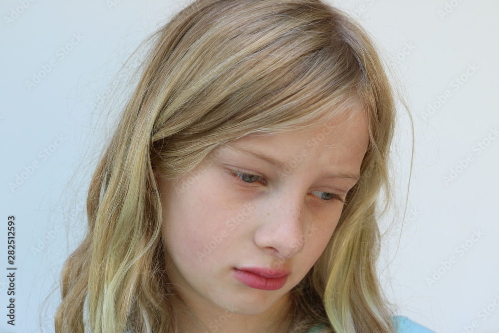 Portrait of a sad preteen girl looking down Portrait of a sad preteen girl looking down