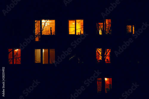 Illuminated in the dark of the night the windows of the houses of an apartment house
