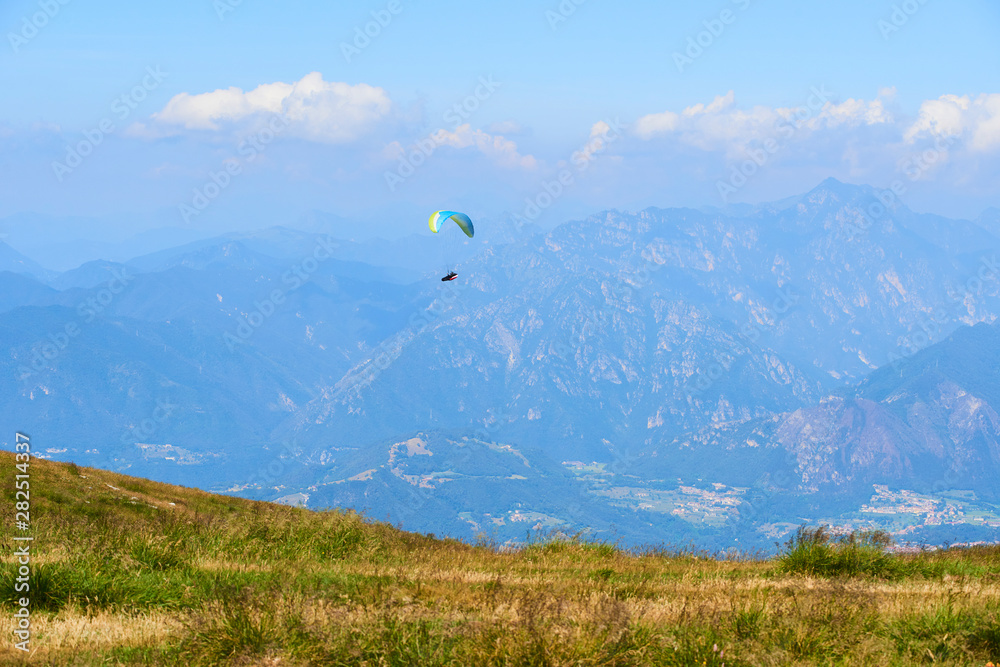 Paraglider flying over the Garda Lake (Lago di Garda or Lago Benaco). Paragliding on Monte Baldo. Panorama of the gorgeous Garda lake surrounded by mountains, Malcesine, Italy Paraglider flying over the Garda Lake (Lago di Garda or Lago Benaco). Paragliding on Monte Baldo. Panorama of the gorgeous Garda lake surrounded by mountains, Malcesine, Italy