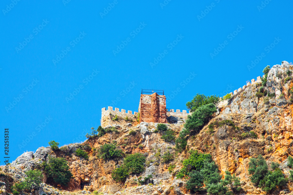 Stone fortress on a rock against the sky. Stone fence on the mountain. Turkey, Alanya