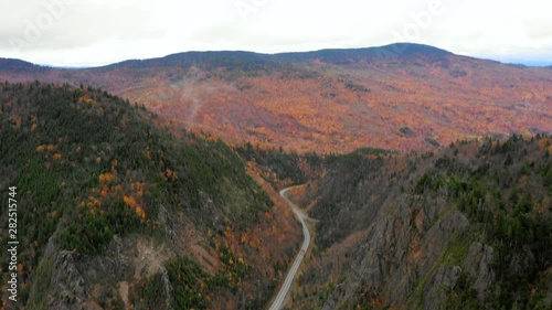 Aerial Pan Up: Colorful, Forest Covered Plain And Hills With Road In Middle - Dixville Notch, New Hampshire photo