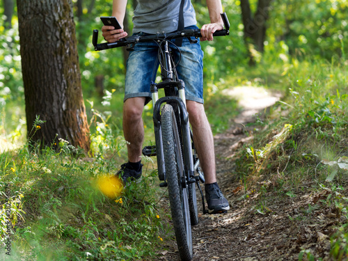 Cyclist in the woods on a mountain bike. See the route in your phone