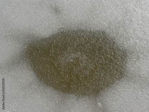 Ice hole in the ice for winter fishing. Cracks and hole in ice on pond dark ice in hole from stone. Children game