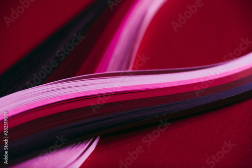 Abstract rainbow paper wave pattern on red background photo