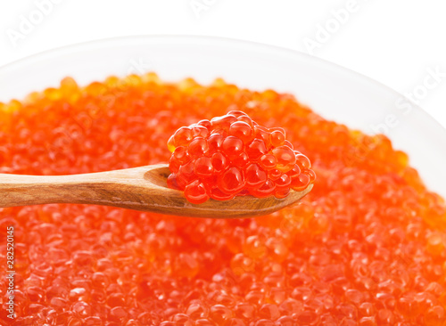 little wooden spoon with red caviar over bowl