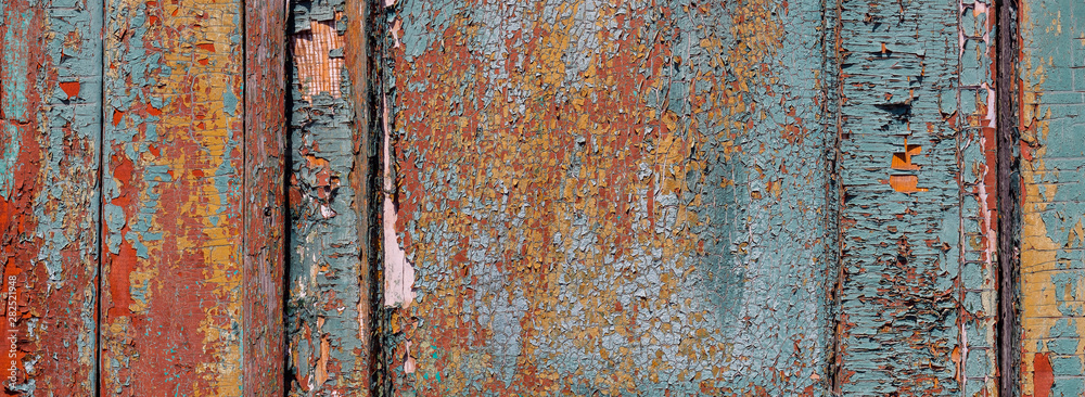 Multilayer paint. Peeling paint on a wooden surface. Texture of the old cracked paint. Cracked paint on a wooden surface