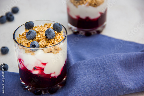 Granola with yogurt and blueberries over bright background
