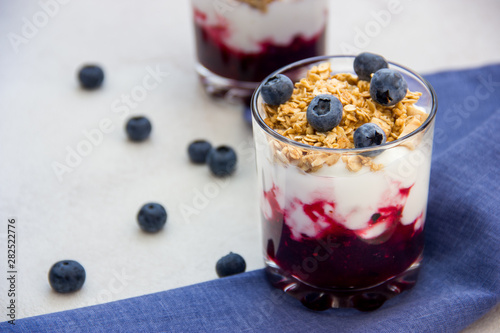 Granola with yogurt and blueberries over bright background