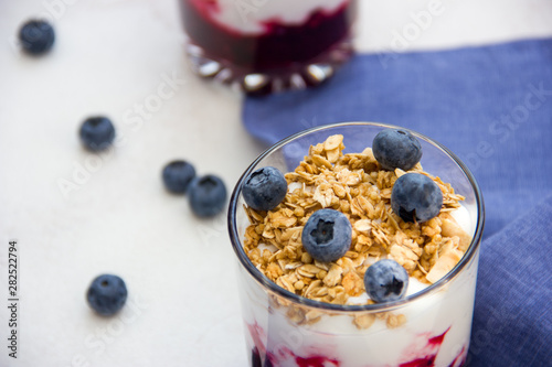 Granola with yogurt and blueberries over bright background