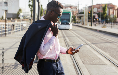 Businessman using his smartphone in city