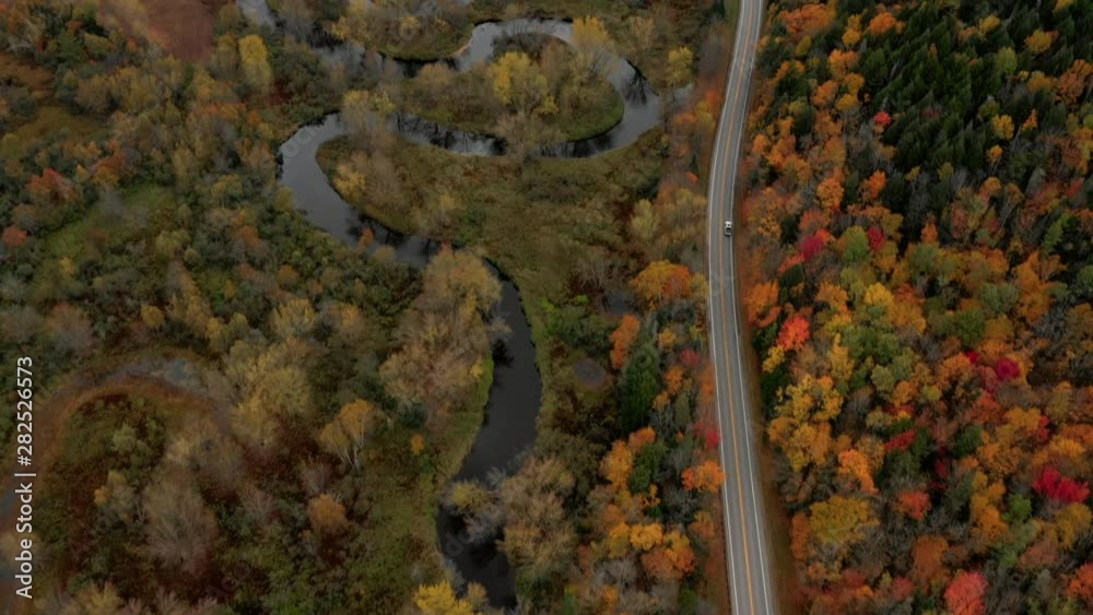 Aerial Pan Up: Car Driving On Road Through Brightly Colored, Forest Covered Plain - Dixville Notch, New Hampshire Aerial Pan Up: Car Driving On Road Through Brightly Colored, Forest Covered Plain - Dixville Notch, New Hampshire