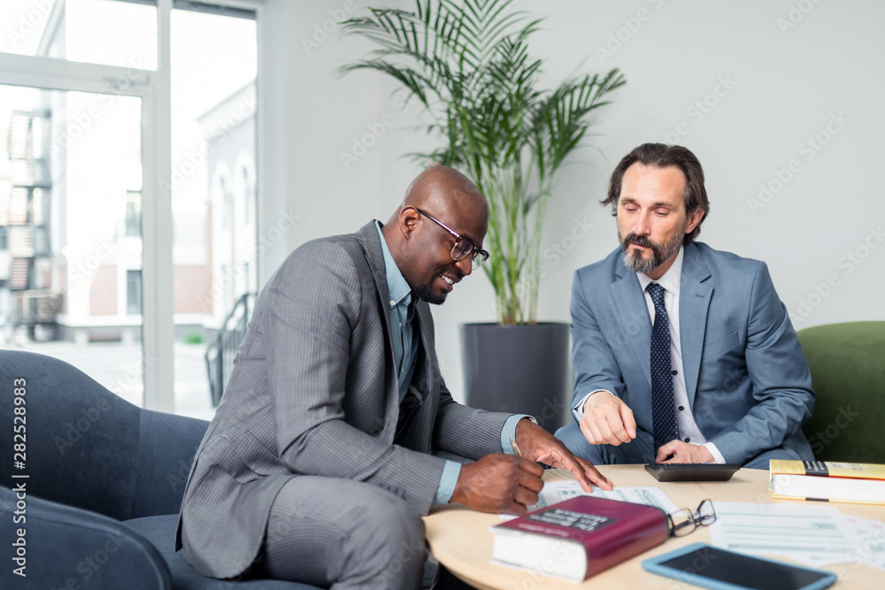 Dark-skinned businessman having consultation of tax specialist Dark-skinned businessman having consultation of tax specialist